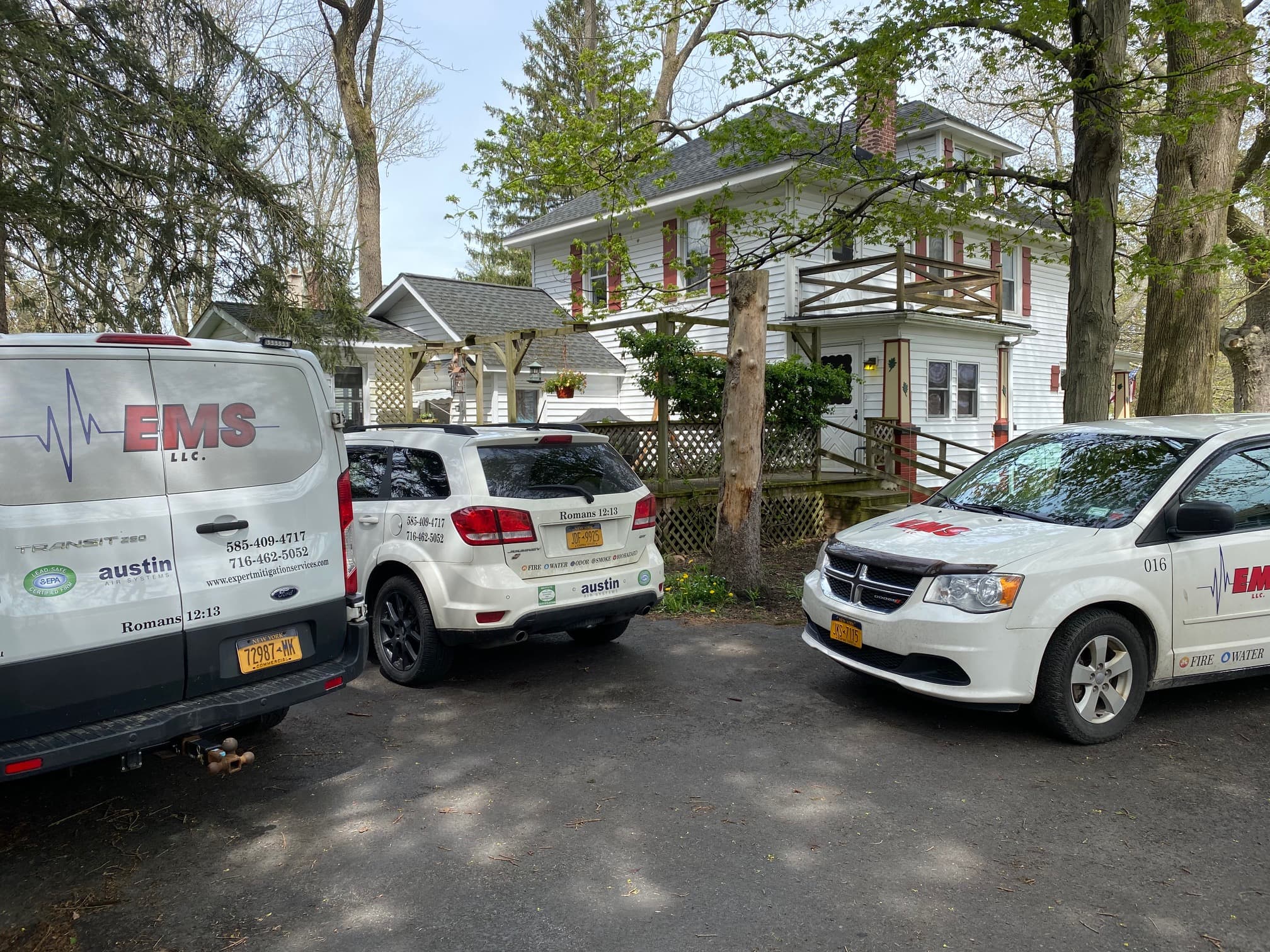 Emergency restoration vehicles parked at residential property for damage mitigation